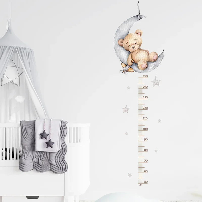 Toise murale ourson sur la lune et étoiles grises à côté d'un lit bébé blanc
