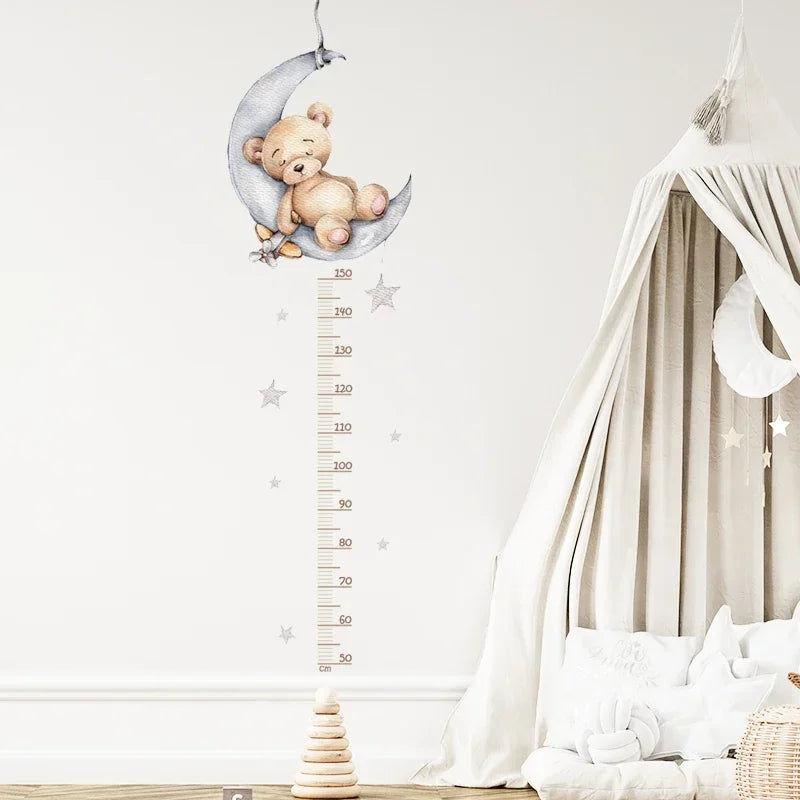 Stickers muraux toise ourson endormi sur une lune grise, étoiles et règle graduée de 50 à 150 cm près d'un ciel de lit