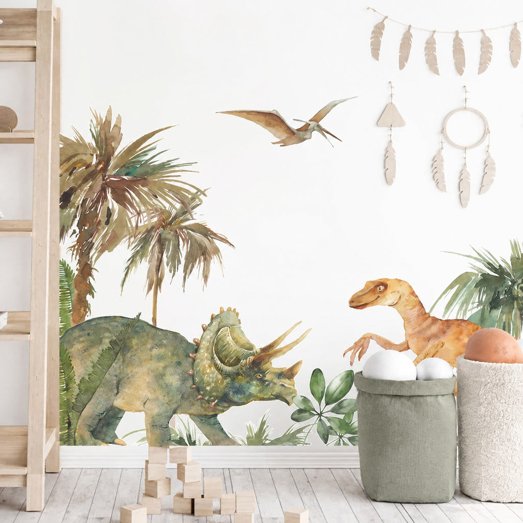 Stickers tricératops et raptor aquarelle sur un mur blanc, échelle en bois, décor de plumes et sac de rangement en lin vert sauge
