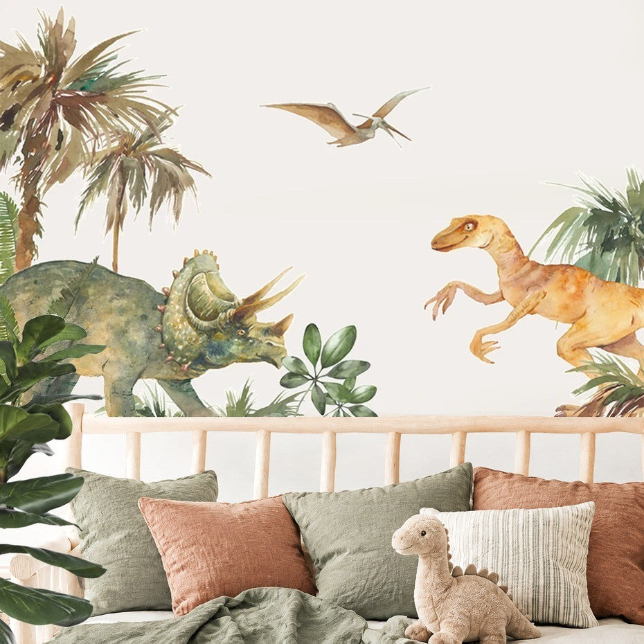 Tricératops, raptor et ptérosaure en stickers aquarelle au-dessus d'une tête de lit en bois et de coussins sauge et terracotta