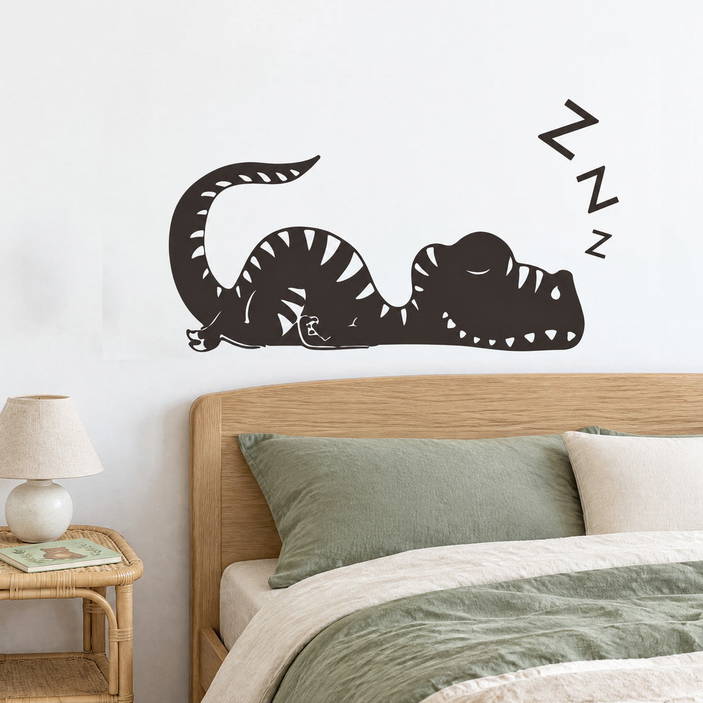 Sticker mural dinosaure endormi noir avec trois Z au-dessus d'une tête de lit en chêne clair