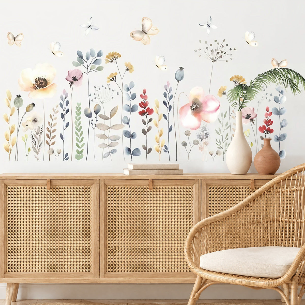Stickers muraux fleurs des champs et coquelicots au-dessus d'un buffet en bois cannage et d'un fauteuil en rotin dans un salon