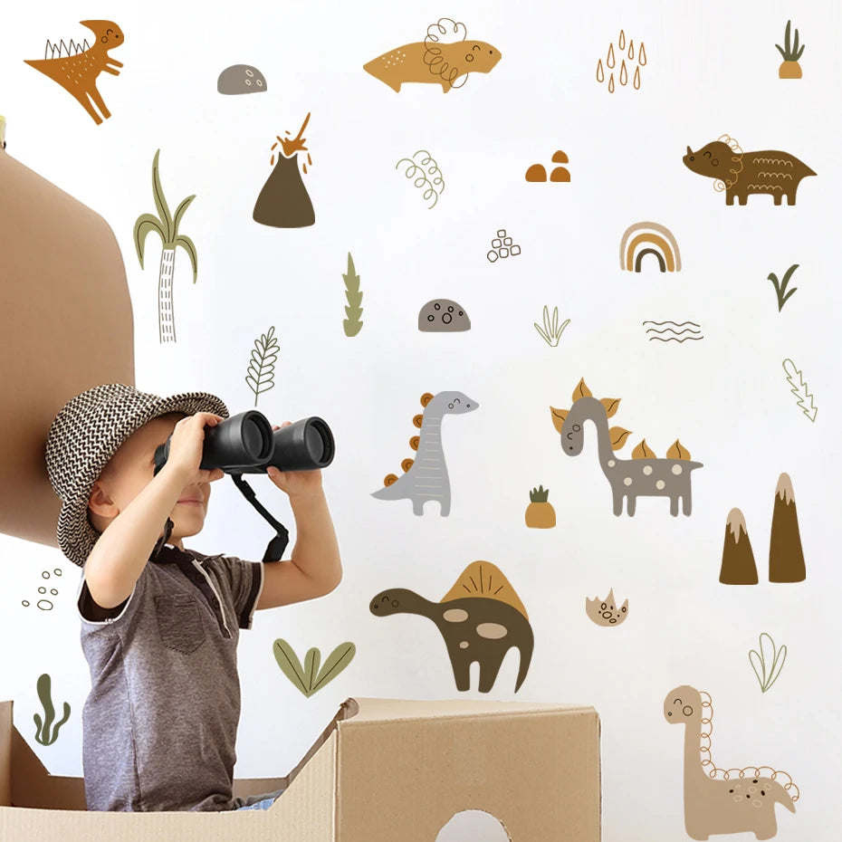 Enfant aux jumelles dans un carton devant un mur de stickers dinosaures bohème, montagnes et volcan