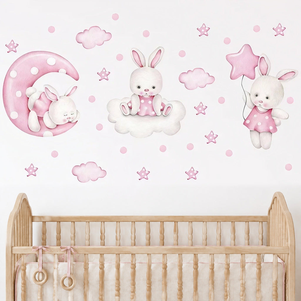 Stickers lapins, lune, nuages et étoiles roses posés au-dessus d'un lit à barreaux en bois naturel