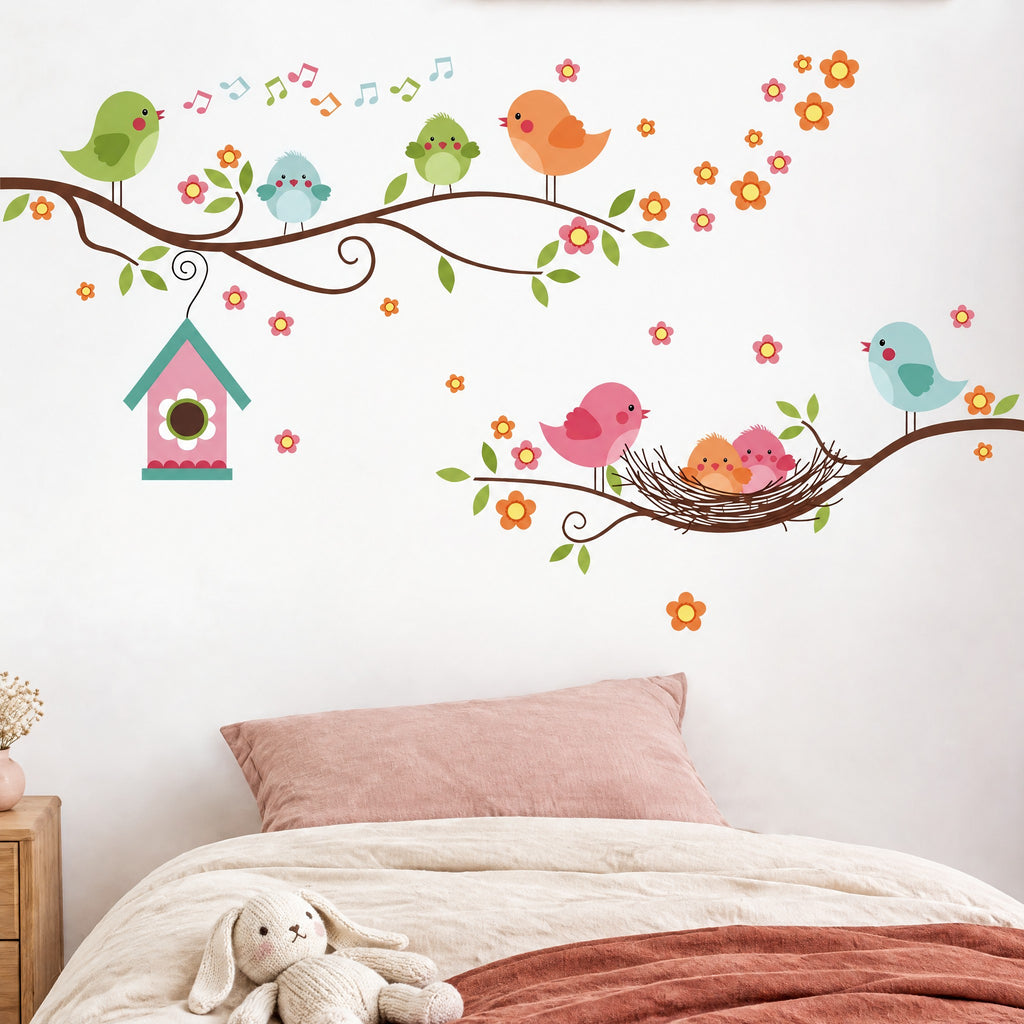 Stickers muraux branches fleuries et oiseaux au-dessus d'un lit d'enfant en linge crème et terracotta