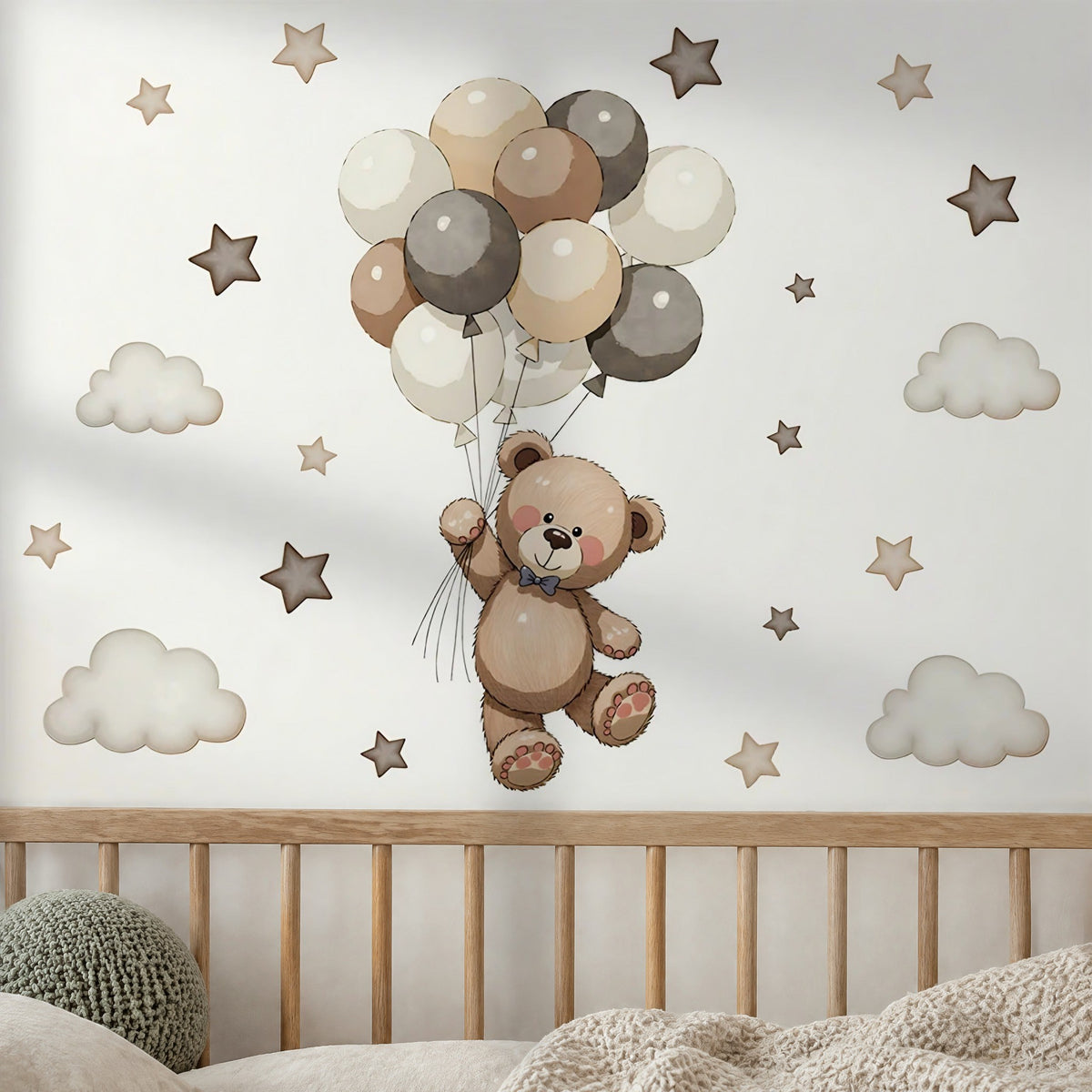 Stickers muraux ourson suspendu à des ballons beige et gris, étoiles et nuages au-dessus d'un lit bébé à barreaux en chêne clair