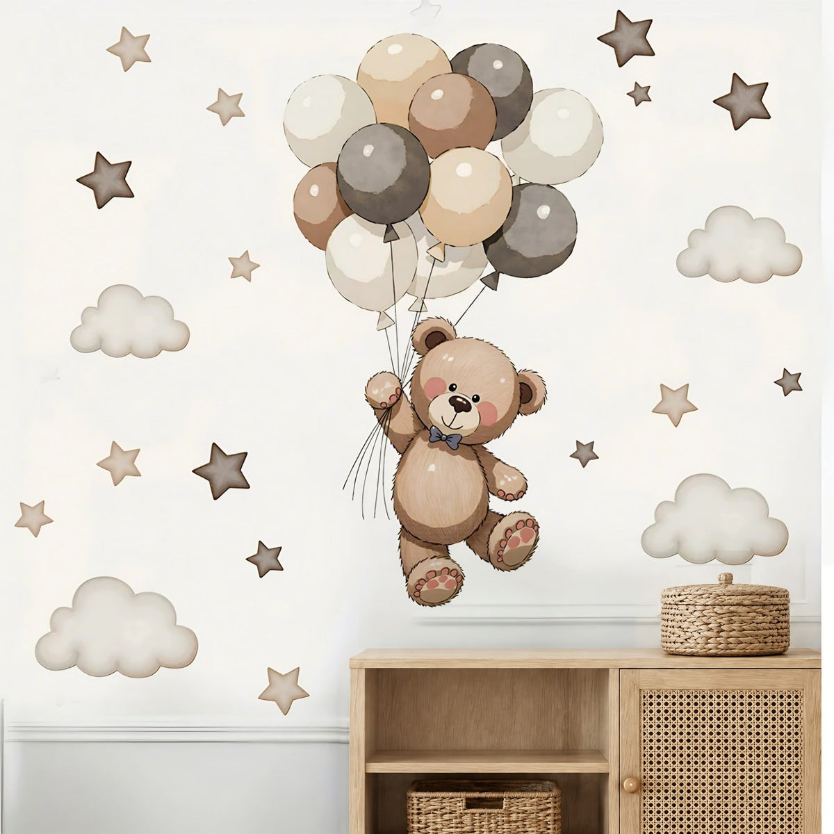 Composition ourson aux ballons avec étoiles taupe et nuages blanc cassé au-dessus d'un meuble canné en chêne et d'un panier tressé
