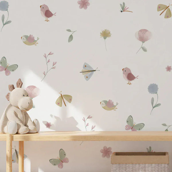 Butterfly and bird wall stickers above a wooden bench with a soft toy