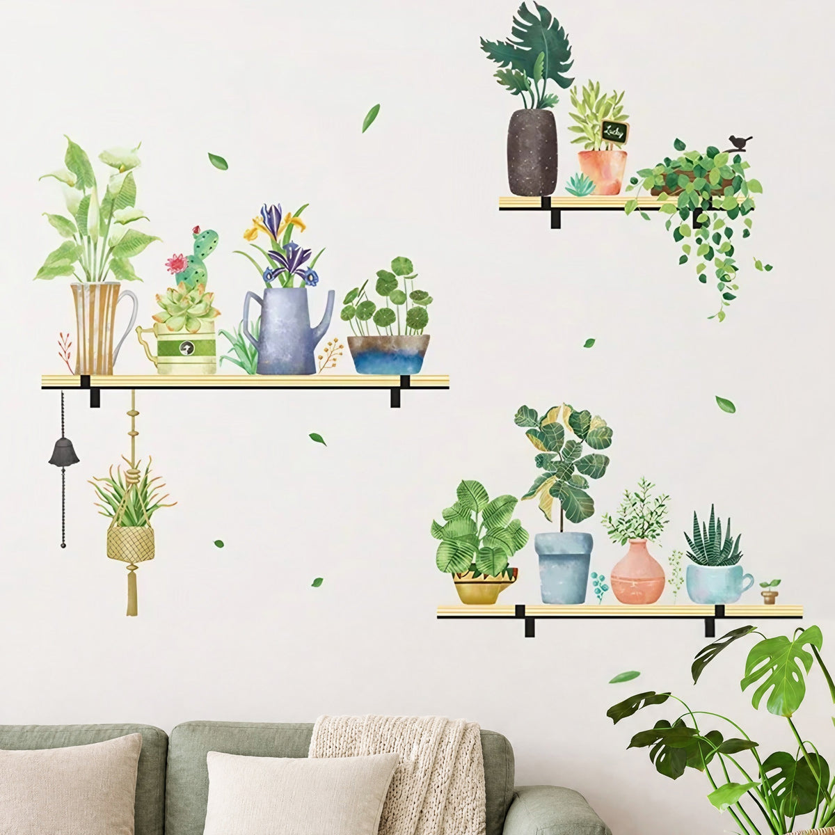 Stickers muraux trois étagères de plantes vertes aquarelle dans un salon, au-dessus d'un canapé en lin vert sauge