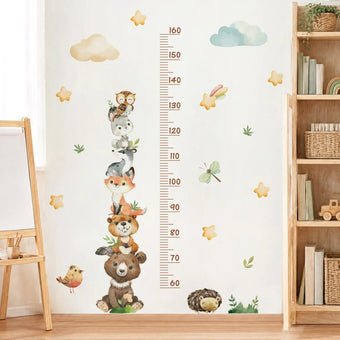 Woodland animals height chart wall sticker with a 60 to 160 cm ruler between a light oak easel and a wooden shelf with woven baskets