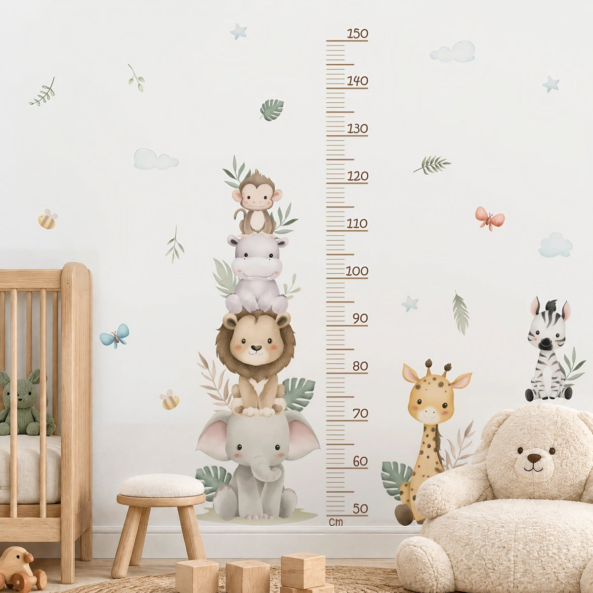 Stickers muraux toise safari dans une chambre de bébé, girafe et zèbre près d'un lit à barreaux en bois clair et d'un fauteuil ours en bouclette