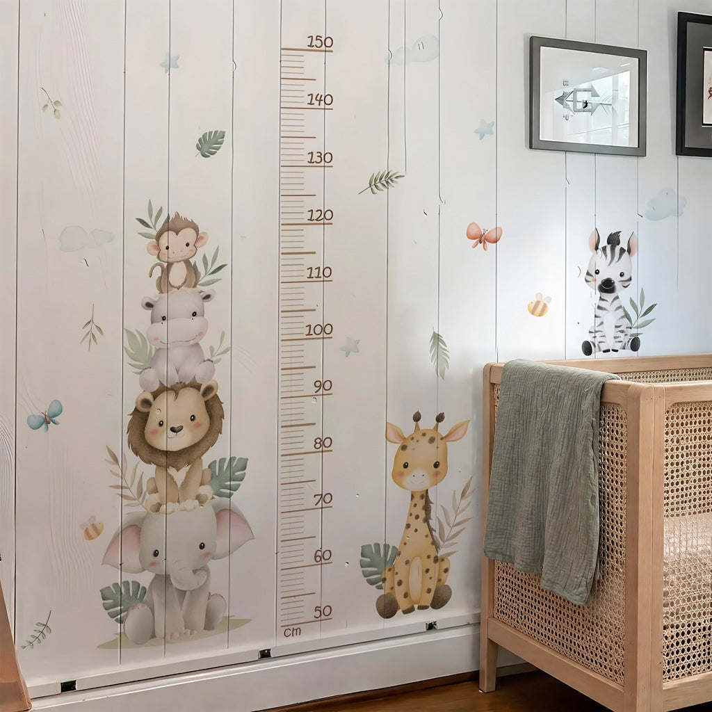 Toise animaux de la savane aquarelle sur un mur en lames de bois blanc, à côté d'un lit bébé en bois et cannage