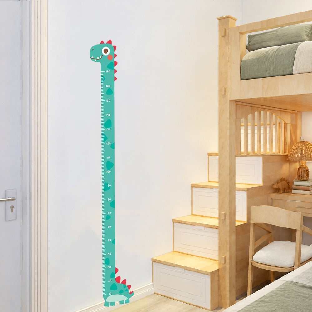 Stickers muraux toise dinosaure vert d'eau graduée de 10 à 170 cm sur un mur blanc, près d'un lit mezzanine en bois clair au linge vert sauge