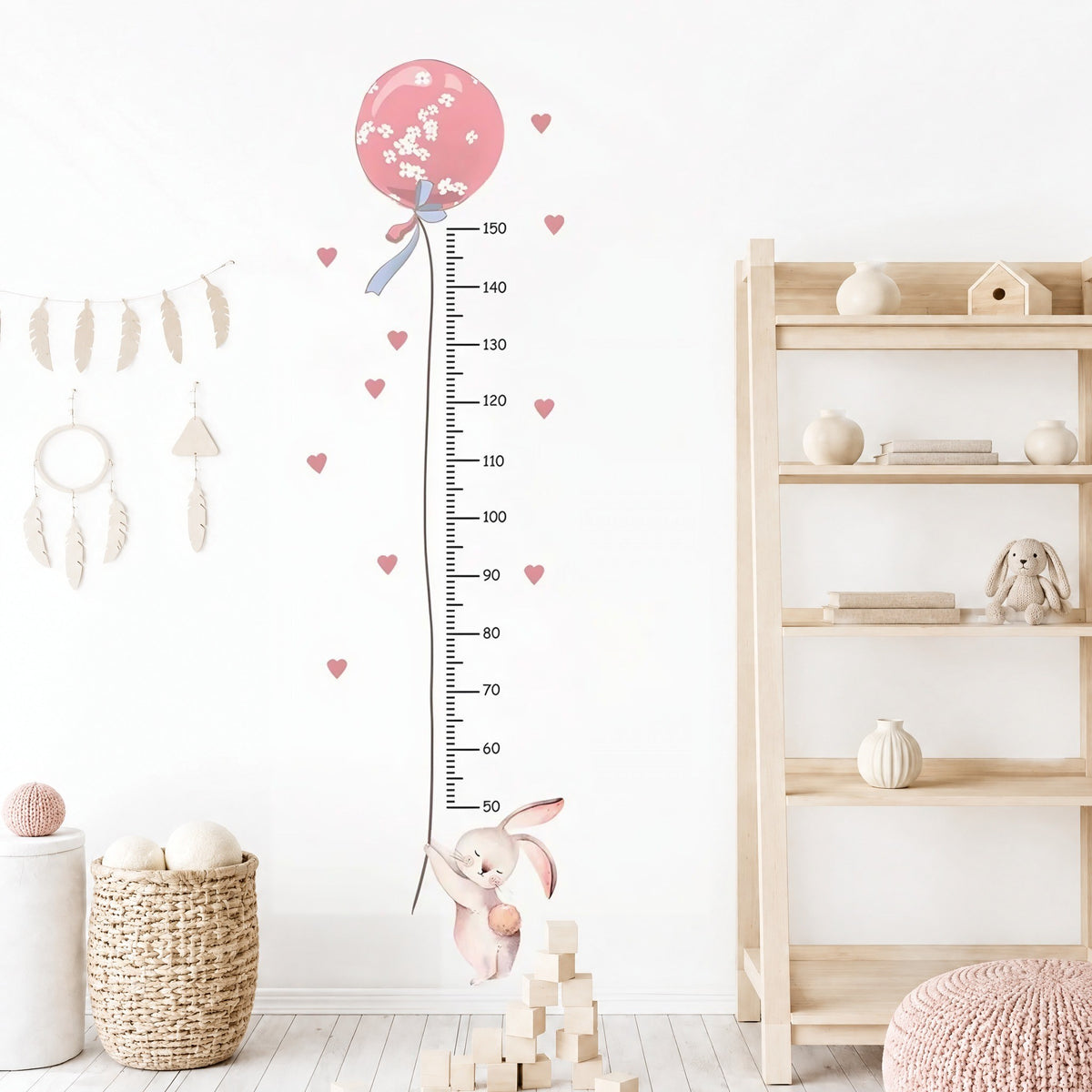 Toise lapin et ballon rose sur un mur blanc près d'une étagère en bois et d'un panier tressé