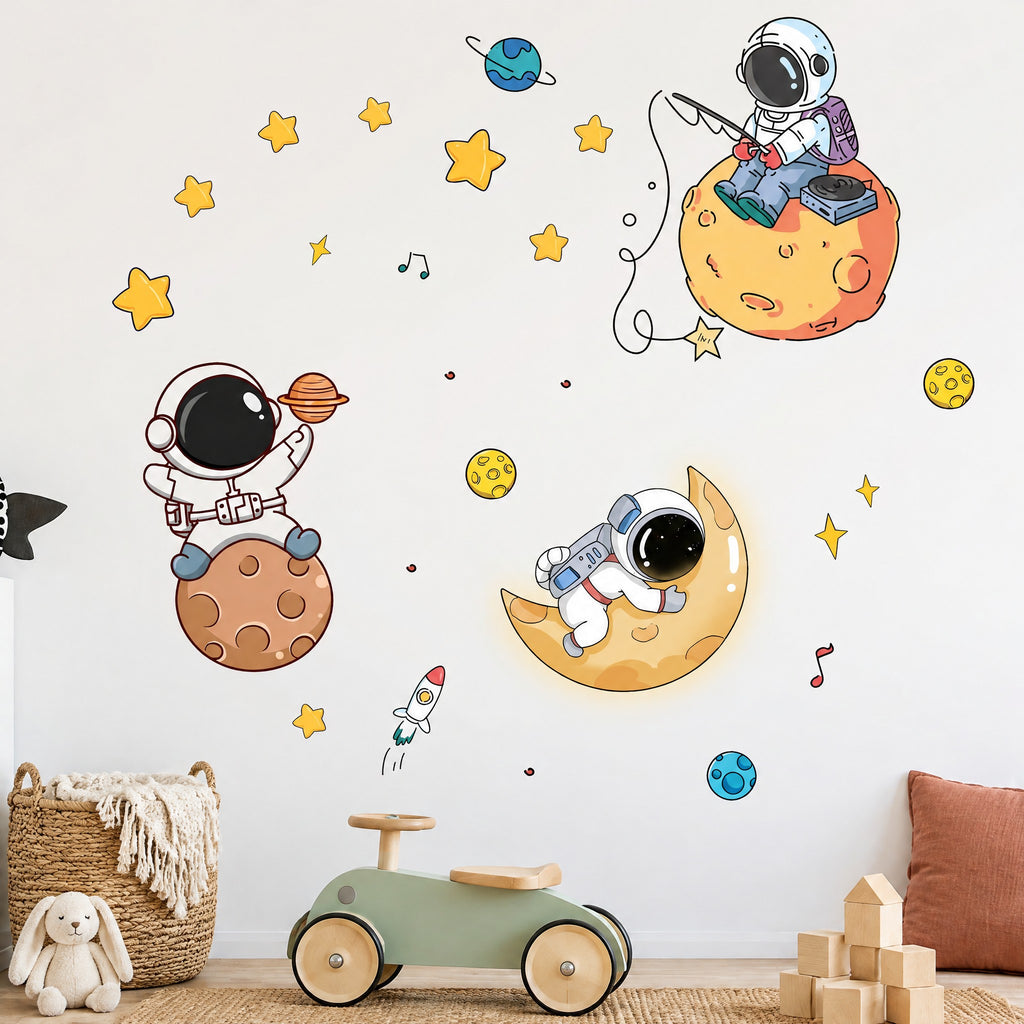 Stickers muraux trois astronautes, lune, planètes et étoiles sur un mur blanc de chambre de garçon, voiture porteur sauge et panier en rotin